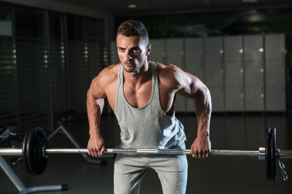 homem realizando na academia o exercício remada curvada com a barra